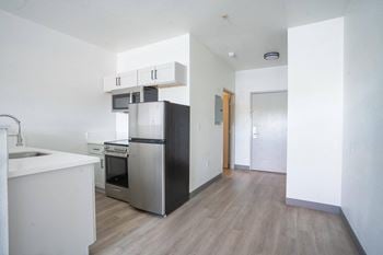 An empty kitchen with a refrigerator and a sink